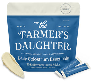The Farmer's Daughter Daily Colostrum Essentials packaging with two travel sticks on a white background